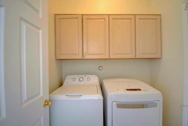 washroom featuring washing machine and clothes dryer and cabinet space