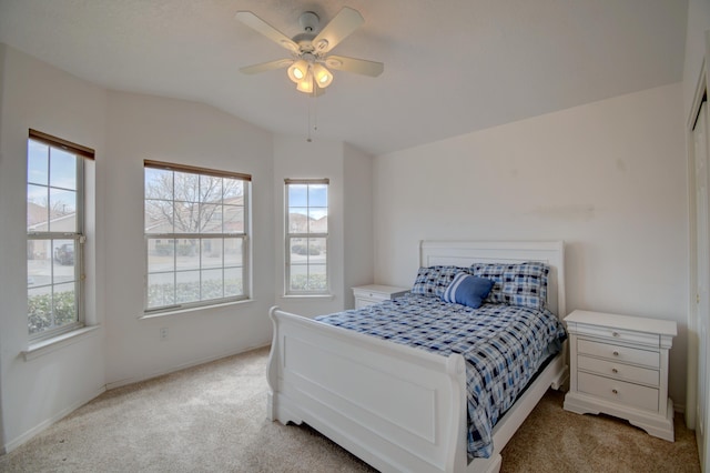 bedroom featuring light carpet, lofted ceiling, and a ceiling fan