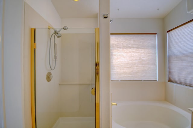 bathroom featuring a bath and a shower stall