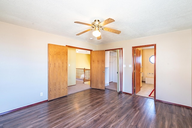 unfurnished bedroom with connected bathroom, ceiling fan, wood finished floors, a closet, and a textured ceiling