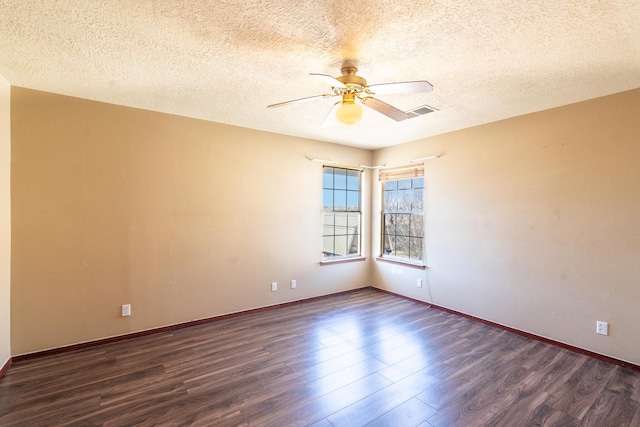 unfurnished room with baseboards, a textured ceiling, dark wood finished floors, and a ceiling fan