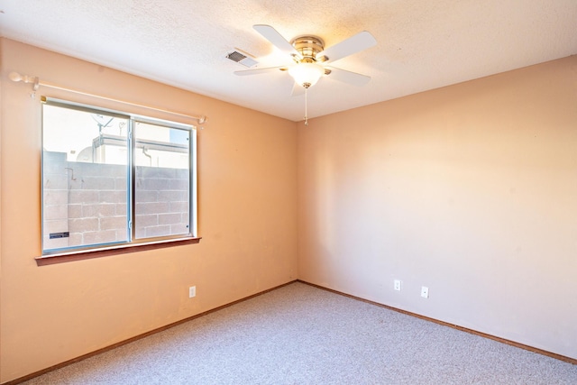 empty room featuring visible vents, baseboards, carpet, and a textured ceiling