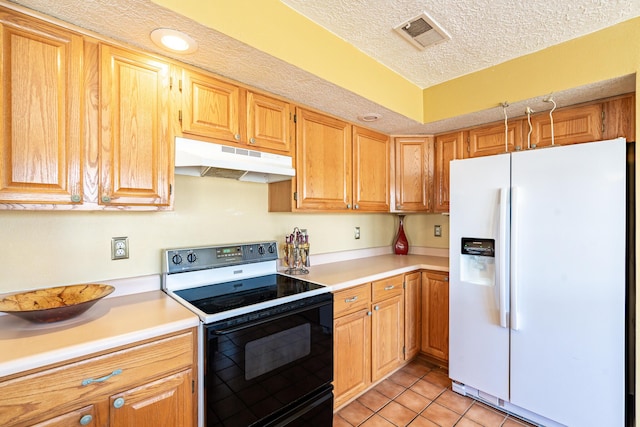 kitchen with visible vents, under cabinet range hood, white refrigerator with ice dispenser, electric range oven, and light tile patterned floors