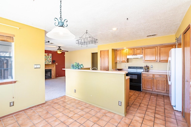 kitchen with visible vents, freestanding refrigerator, electric range oven, light countertops, and under cabinet range hood