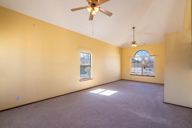 carpeted spare room featuring a wealth of natural light, baseboards, and ceiling fan