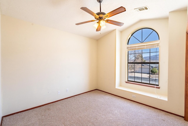 unfurnished room with baseboards, visible vents, carpet floors, lofted ceiling, and ceiling fan