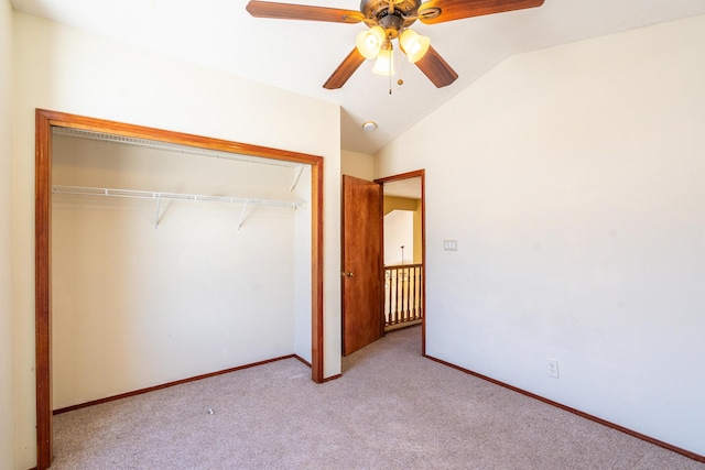 unfurnished bedroom featuring carpet, baseboards, ceiling fan, vaulted ceiling, and a closet