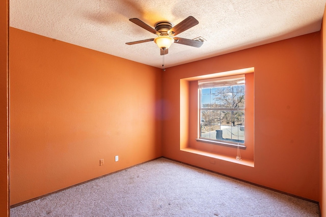 spare room with a textured ceiling, carpet floors, and ceiling fan