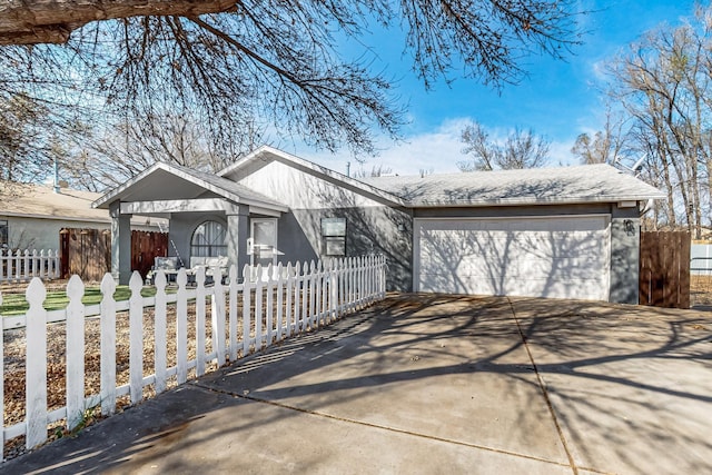 view of front of home featuring a fenced front yard, an attached garage, and driveway