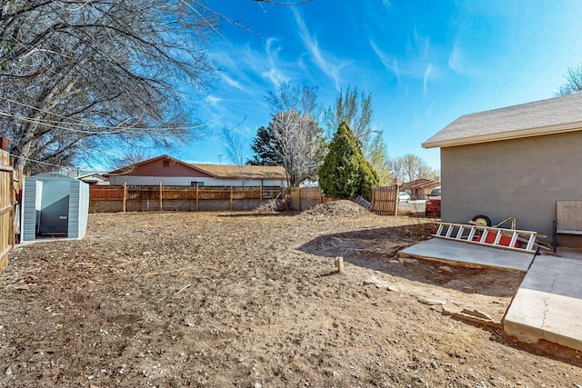 view of yard featuring a patio area, an outbuilding, and a fenced backyard