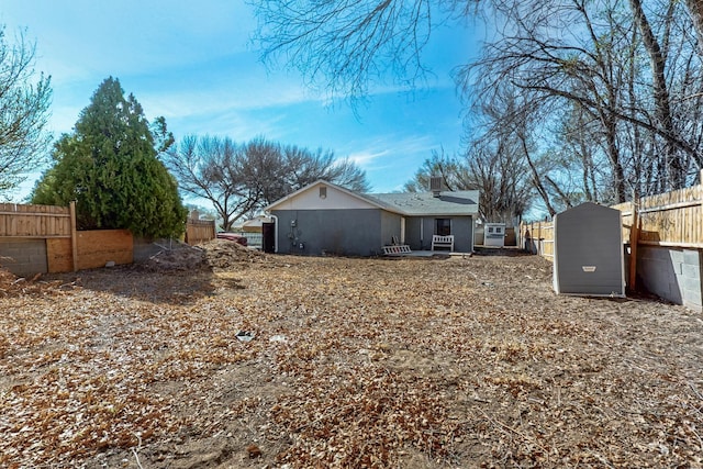 rear view of property with stucco siding and fence