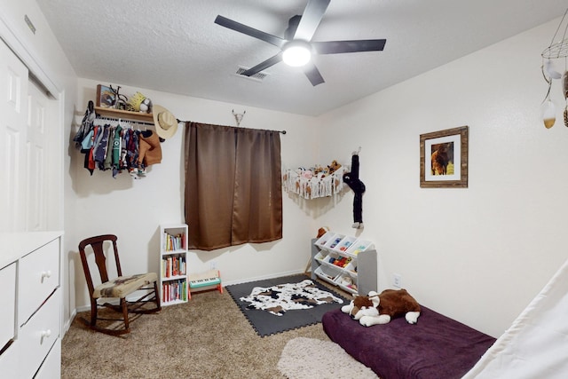 bedroom featuring carpet, visible vents, ceiling fan, a closet, and a textured ceiling