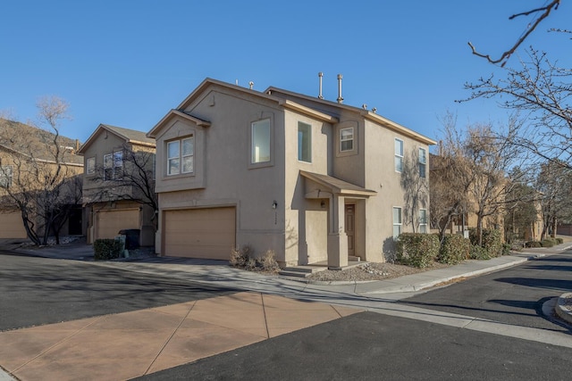 view of front of home featuring concrete driveway, a garage, and stucco siding