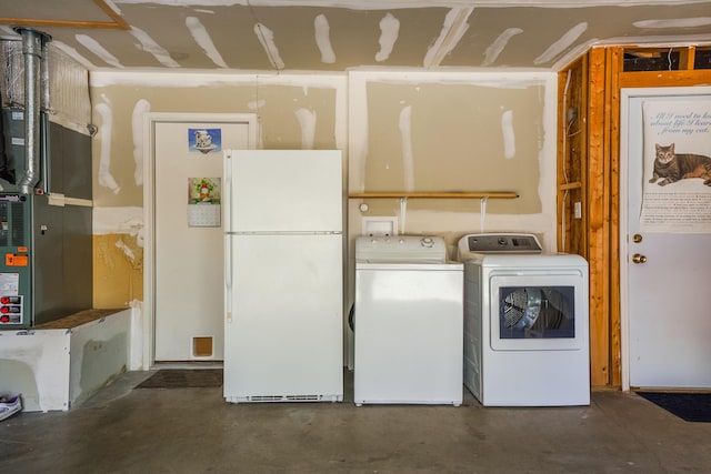 washroom with heating unit, laundry area, and washing machine and clothes dryer