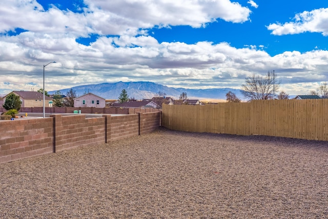 view of yard featuring a fenced backyard and a mountain view