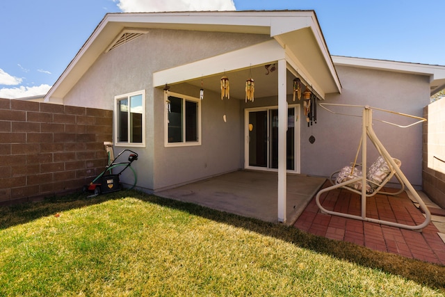 back of property featuring a yard, stucco siding, a patio, and fence