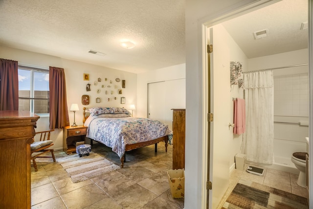 bedroom with visible vents, a textured ceiling, and baseboards