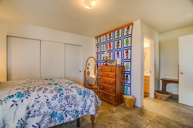 bedroom with a closet, a textured ceiling, and connected bathroom