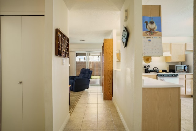 corridor featuring light tile patterned floors and baseboards