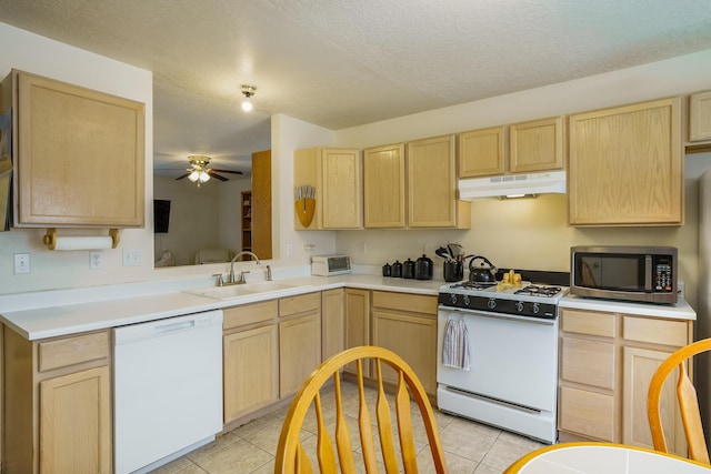 kitchen with light brown cabinetry, white appliances, under cabinet range hood, and a sink