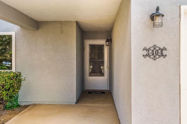 entrance to property featuring stucco siding