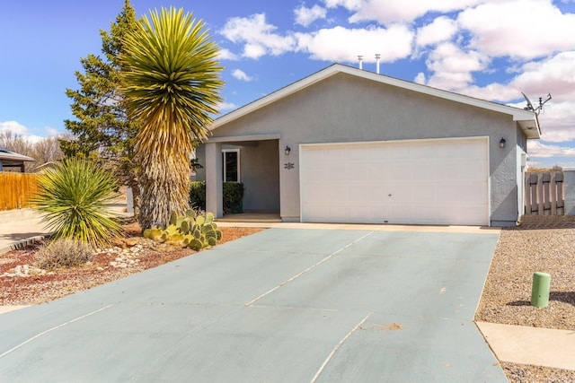 ranch-style home with stucco siding, a garage, driveway, and fence