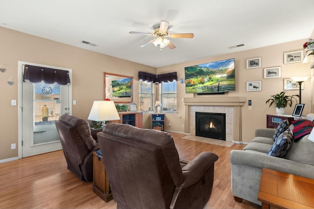 living area with light wood finished floors, visible vents, and a ceiling fan