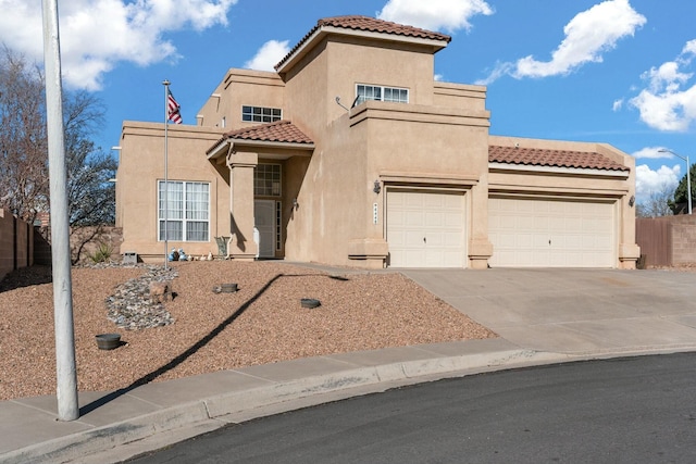 mediterranean / spanish-style home with stucco siding, fence, a garage, and a tile roof