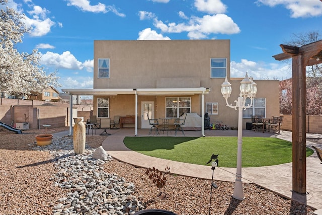 back of property featuring stucco siding, a patio area, and fence