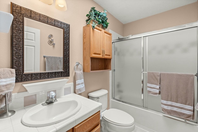 bathroom featuring enclosed tub / shower combo, toilet, and vanity