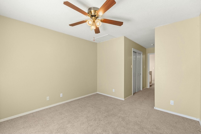 empty room featuring light carpet, baseboards, and a ceiling fan