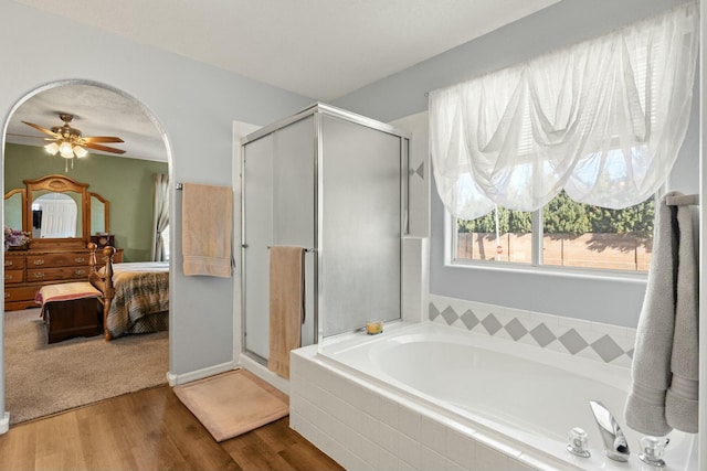 full bath with wood finished floors, a garden tub, ensuite bath, and a shower stall