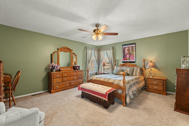 carpeted bedroom featuring visible vents, baseboards, a textured ceiling, and a ceiling fan