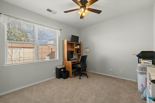 carpeted office featuring a ceiling fan, baseboards, and visible vents