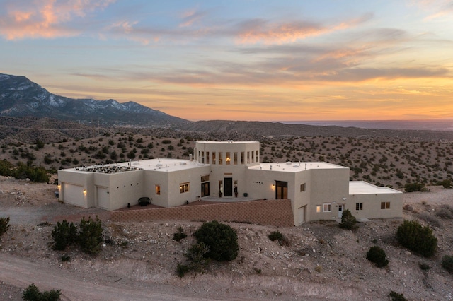 exterior space with a mountain view, driveway, an attached garage, and stucco siding