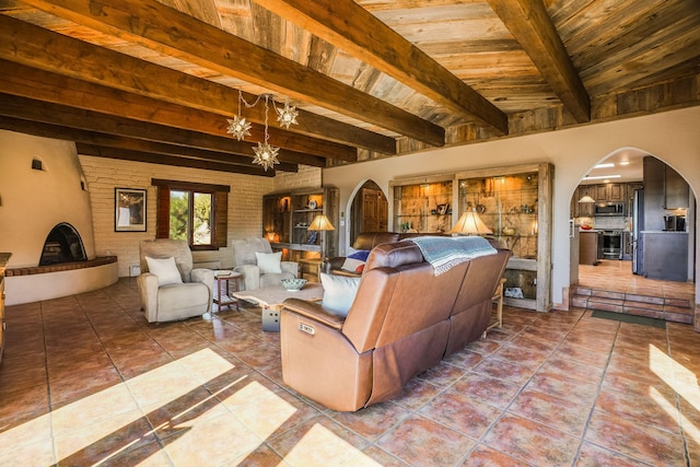 tiled living area featuring wooden ceiling, a notable chandelier, arched walkways, and beam ceiling