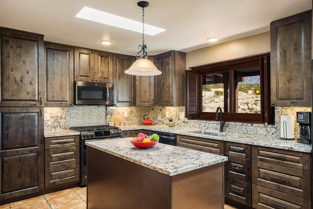 kitchen featuring a sink, a skylight, tasteful backsplash, and stainless steel appliances