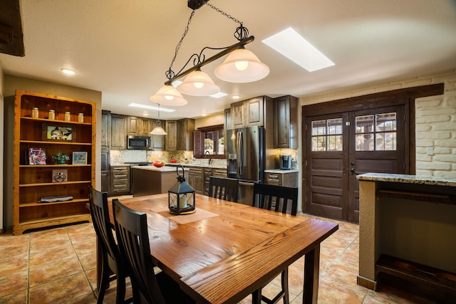 dining room featuring a skylight, light tile patterned floors, and recessed lighting