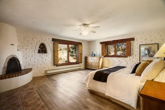 bedroom with a textured ceiling, wood finished floors, a ceiling fan, and a baseboard radiator