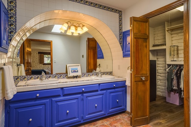 bathroom with a sink, decorative backsplash, ensuite bath, and double vanity