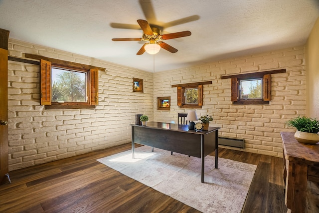 office area featuring a wealth of natural light, baseboard heating, wood finished floors, a textured ceiling, and a ceiling fan