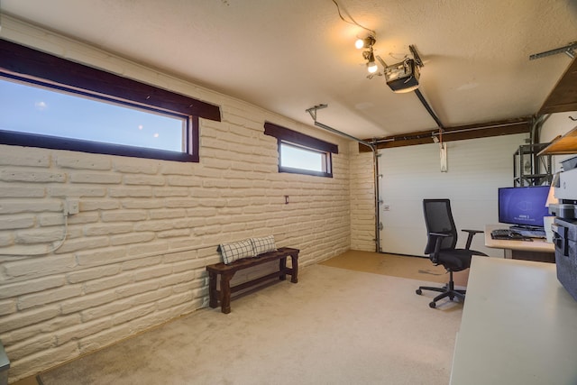 home office featuring carpet flooring, a garage, and brick wall