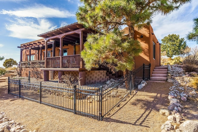 view of side of home featuring stucco siding and fence