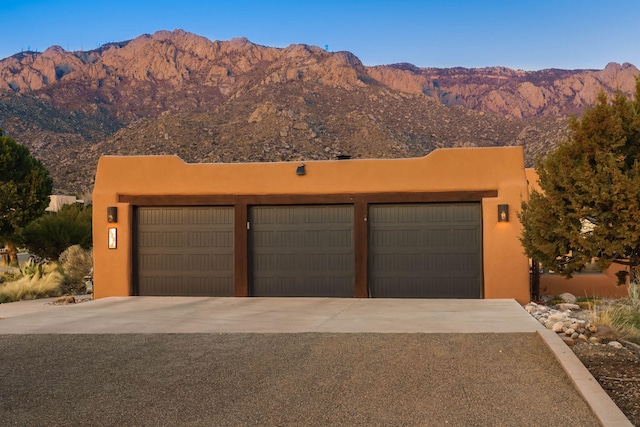 view of front of house with a mountain view, a garage, and stucco siding