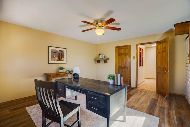 home office featuring dark wood-style floors, a ceiling fan, and baseboards