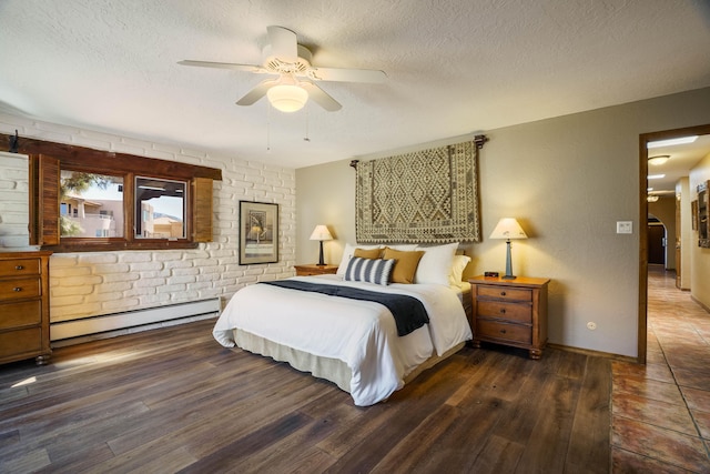 bedroom with baseboard heating, a textured ceiling, baseboards, and wood finished floors