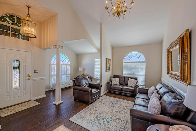 living area featuring a notable chandelier, a healthy amount of sunlight, dark wood-style flooring, and ornate columns