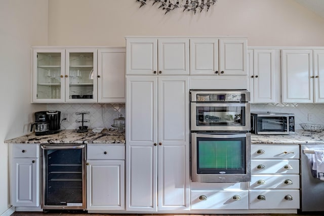 kitchen with wine cooler, white cabinets, stainless steel appliances, and glass insert cabinets