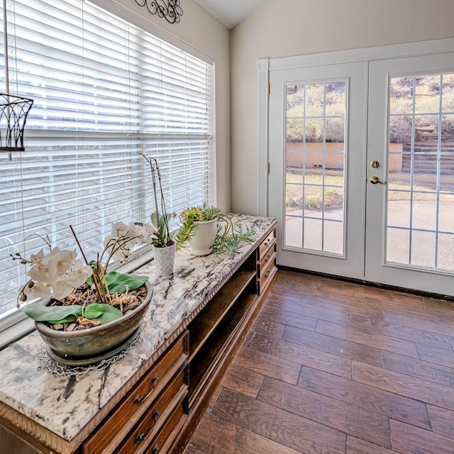 interior space featuring dark wood-type flooring, french doors, and lofted ceiling