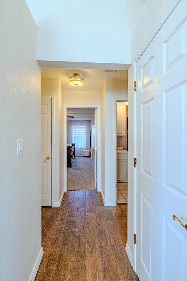 hall with baseboards and dark wood-style flooring